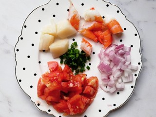 番茄海鲜炒意面,煮面的时候准备食材：番茄去皮切块，洋葱切丁，贝柱和虾解冻洗干净后切小块，葱切碎