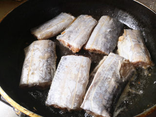 家常焖带鱼,平底锅里放适量的油，油热后，把带鱼放入锅中，小火慢煎