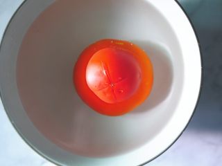 肉酱贝壳面,番茄顶部切十字花刀，放入热水中烫约30秒