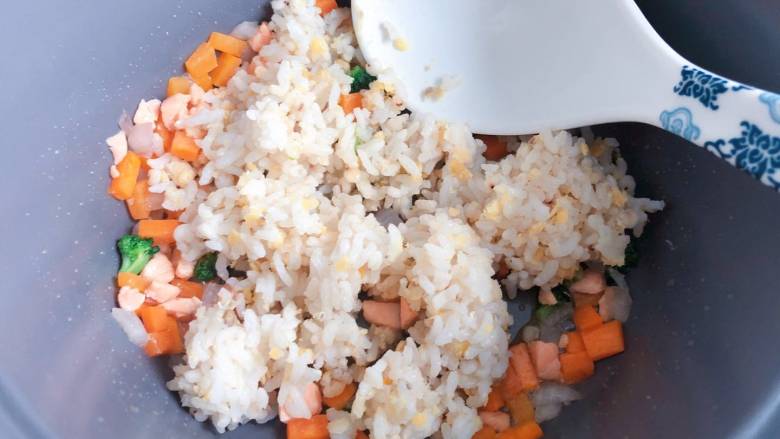 【宝宝辅食】三文鱼耳光炒饭,最后放入米饭，用勺子背部把米饭压开，与配菜一起翻炒均匀即可