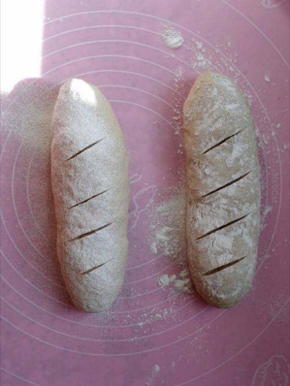 无油无糖的瑞士乡村面包,整形成两个长条，筛少许干粉，用刀片划几刀