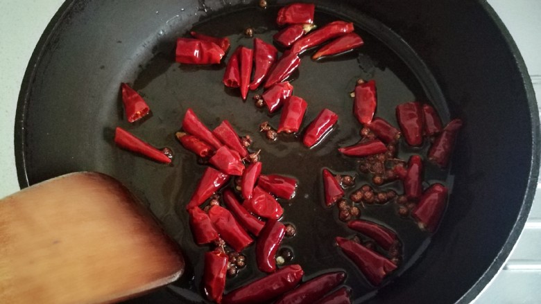 花椒鸡丁,锅中留30亳升的油，放入花椒和干辣椒炒香。