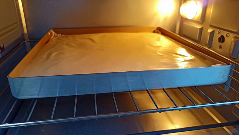 芒果奶油蛋糕,拌好的面糊倒入烤盘（烤盘可以用一张油纸垫一下）轻轻震出气泡放入预热好的烤箱，中层上下火175度烤20分钟。