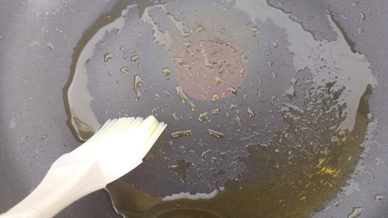 青椒洋葱鸡蛋饼,用刷子把油刷匀。