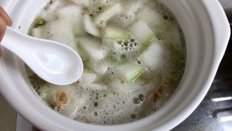 清热消暑，一碗好汤➕蛤蜊冬瓜丸子汤,用勺子撇去汤面浮末