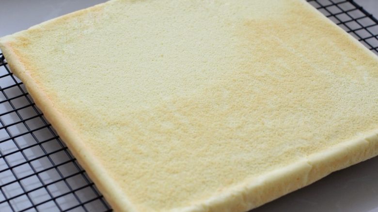 奶油蛋糕卷,然后放入烤箱中层烤约25分钟，出炉后将烤盘倒扣在烤网上，揭去表面油纸晾温