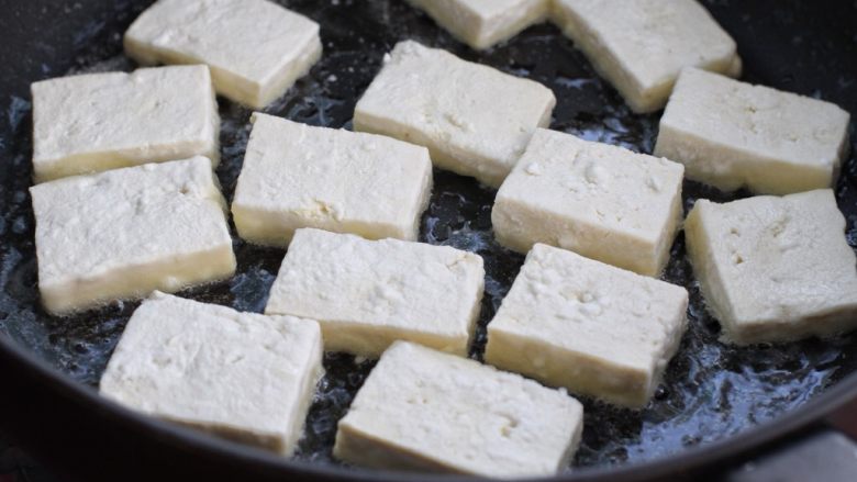 剁椒酱烧豆腐,锅中倒适量食用油烧至七八成热，将豆腐块排放锅中