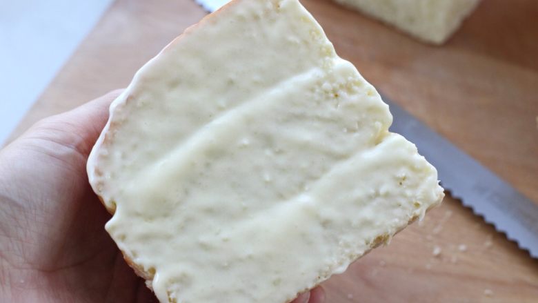 奶酪面包,在切面部位切两刀填入奶酪馅，然后在表面也涂上一层奶酪馅