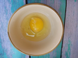 鸡蛋炒腊肠,把鸡蛋打入碗中。