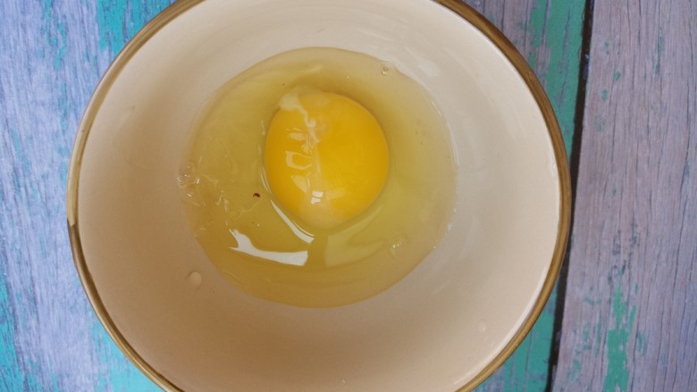 鸡蛋炒腊肠,把鸡蛋打入碗中。