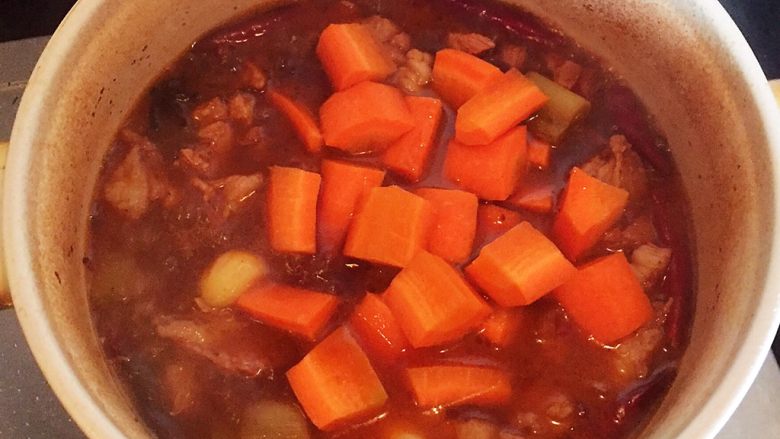 羊肉煲,待汤汁剩下一半，肉快熟时，加入胡萝卜和盐，继续炖煮