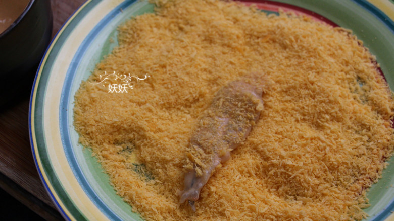 奥尔良日式凤尾虾,将虾肉沾一层面糊，然后裹上一层面包糠。