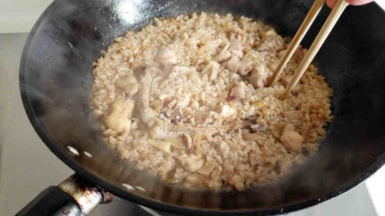 鸡腿焖饭,盖好锅盖，中火烧开，烧至水分被米吸收，打开盖子，用筷子在锅中戳几个洞，转极小的火，盖好盖子焖5分钟左右