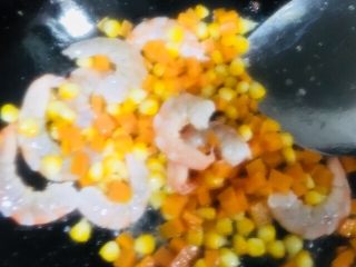 虾仁蛋炒饭,倒入焯好水的胡萝卜和玉米粒快速翻炒均匀