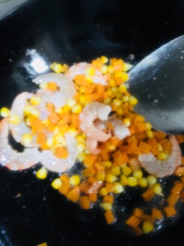 虾仁蛋炒饭,倒入焯好水的胡萝卜和玉米粒快速翻炒均匀
