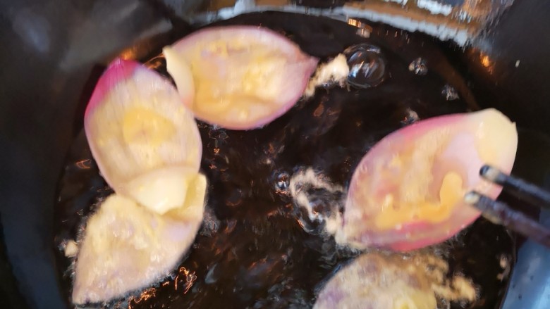 酥炸荷花,油锅烧至七层热后，将蘸有蛋糊的荷花瓣放入锅中炸制