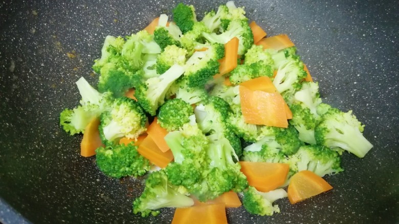 西兰花炒虾仁,下入焯过水的西兰花胡萝卜翻炒均匀。