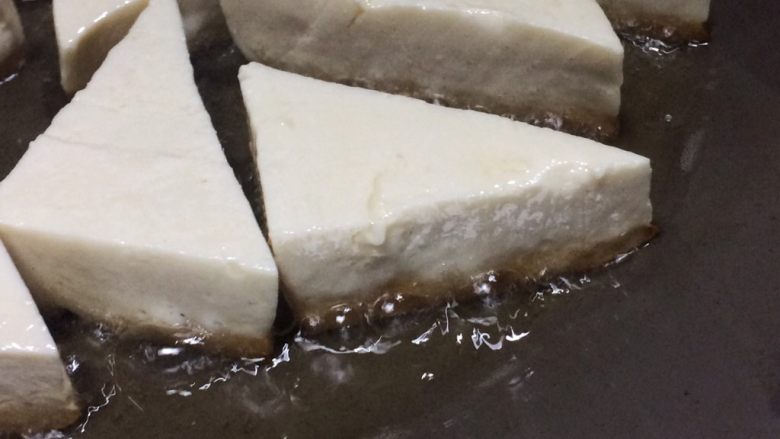 超级下饭的香煎豆腐块,让它自己安静地煎，煎至从侧面看到金黄的边边，如照片所示。