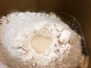 面包机版无糖低脂全麦面包,面粉堆里挖个坑埋入干酵母，因为无糖我们用普通干酵母即可