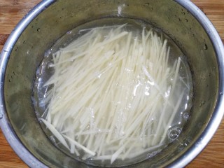 豆豉炝拌青椒土豆丝,切好的土豆丝泡水中，多洗几次洗干净淀粉。