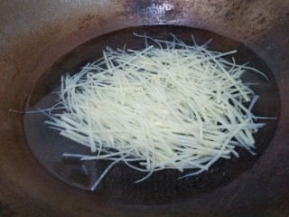 豆豉炝拌青椒土豆丝,水开后倒入土豆丝，焯水一分钟。