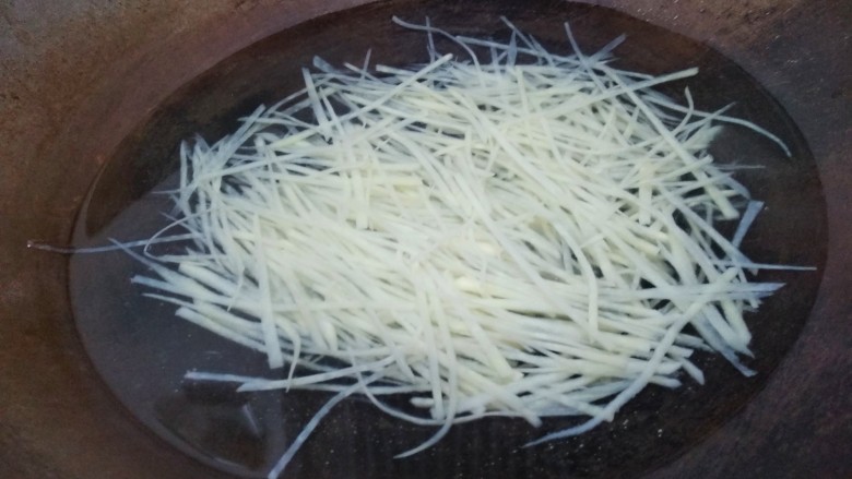 豆豉炝拌青椒土豆丝,水开后倒入土豆丝，焯水一分钟。