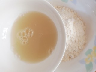 可可椰香毛毛虫(蒸锅版),用温水将酵母和白糖化开后倒入面粉碗中