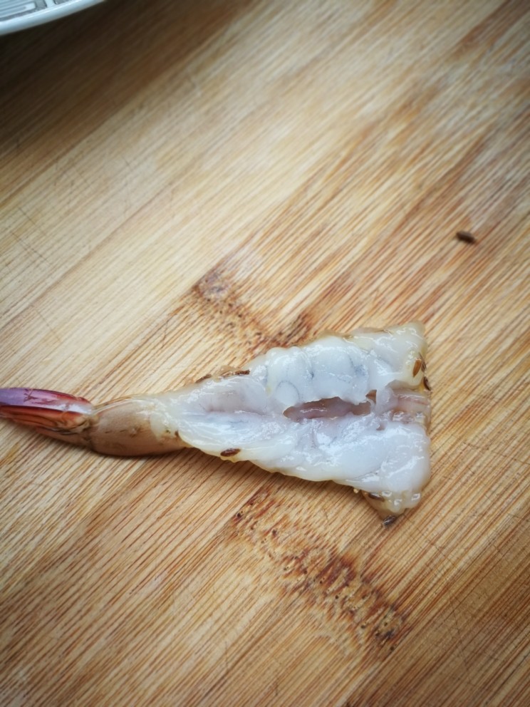 孜然凤尾虾,腌好以后从挑虾线的地方，切开，拍扁