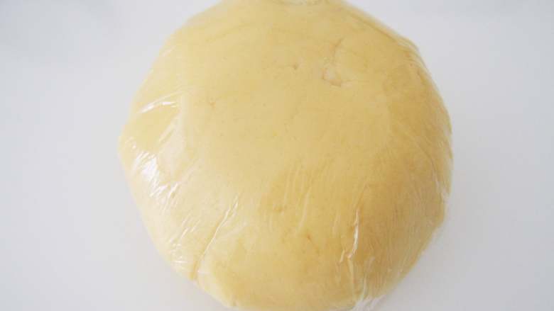 童趣糖霜饼干,将面团切拌均匀后，用保鲜膜包上，放入冰箱冷藏30分钟松弛。