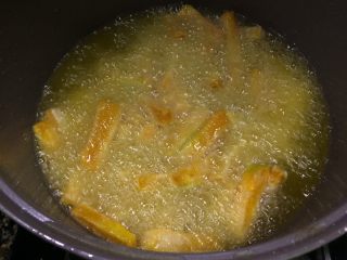 金灿灿的咸蛋黄南瓜条,锅里放适量油烧至8成热后，放入南瓜条炸。