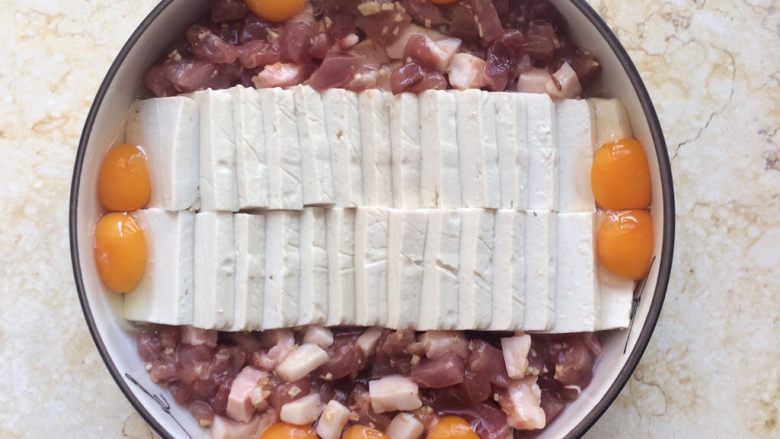 色香味俱全：肉末豆腐抱鹌鹑蛋,将鹌鹑蛋分次放入盘子中。

最好先用筷子稍微弄个小凹坑，再倒入蛋，以免蛋的位置跑偏。