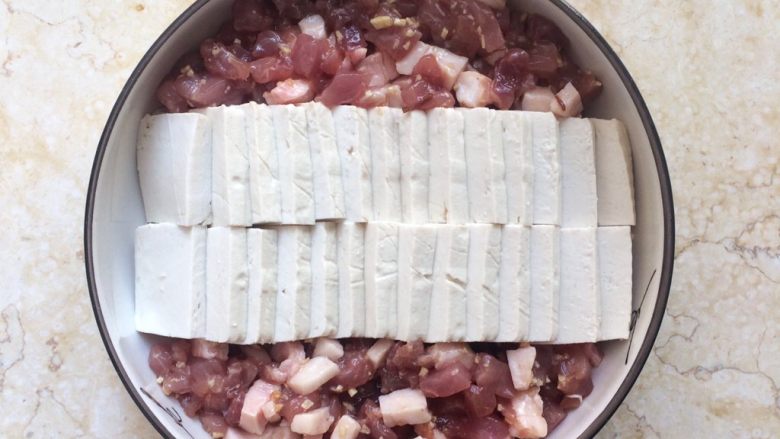 色香味俱全：肉末豆腐抱鹌鹑蛋,将猪肉均匀放入盘子两边。
