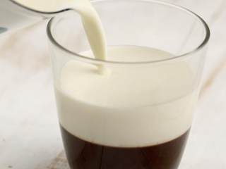 焦糖咖啡奶冻,取出凝固的咖啡冻，倒入牛奶液，放入冰箱冷藏90分钟以上至凝固