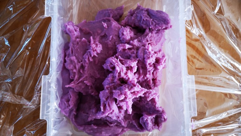 紫薯牛奶小方,稍微放凉一点后铲入垫有保鲜膜的模具中