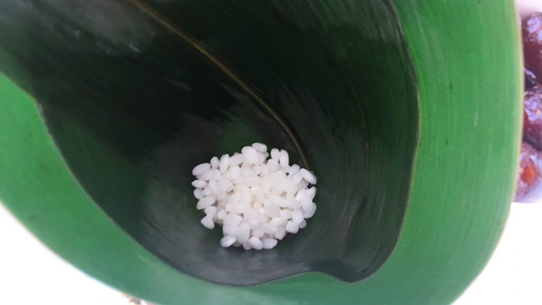 十二谷米蜜枣粽,先在底部铺上一点糯米