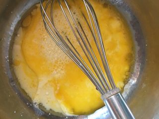 小米糕,在蛋黄里加入牛奶和玉米油，混拌均匀