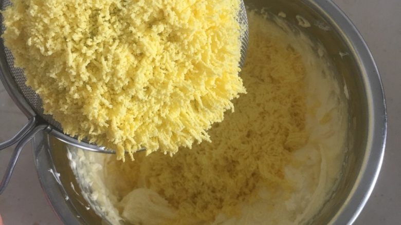 火龙果蛋黄奶豆,用打蛋器把黄油打发微微发白，加入过筛的熟蛋黄，一起打发均匀