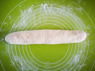 甜甜圈,在揉面垫上撒上少许干面粉，将醒好的面团揉均排气后搓成粗条
