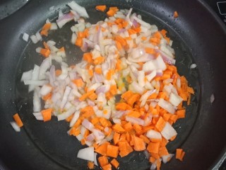 裙边蛋包饭,热锅后倒入油，烧热后倒入洋葱丁个红萝卜丁，翻炒，