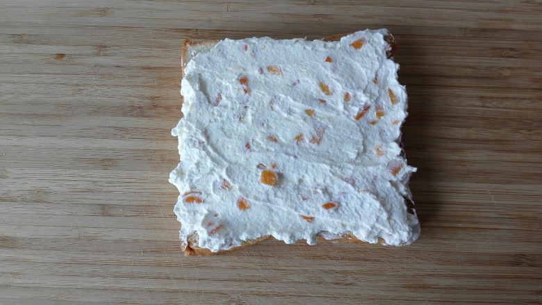 芒果淡奶三明治—夏日里的清凉快手早餐,取一片吐司把奶油涂抹在面包片上