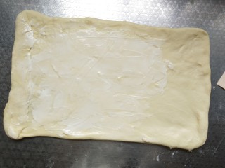 葱香肉松吐司,将面团擀成长方形，表面涂抹沙拉酱