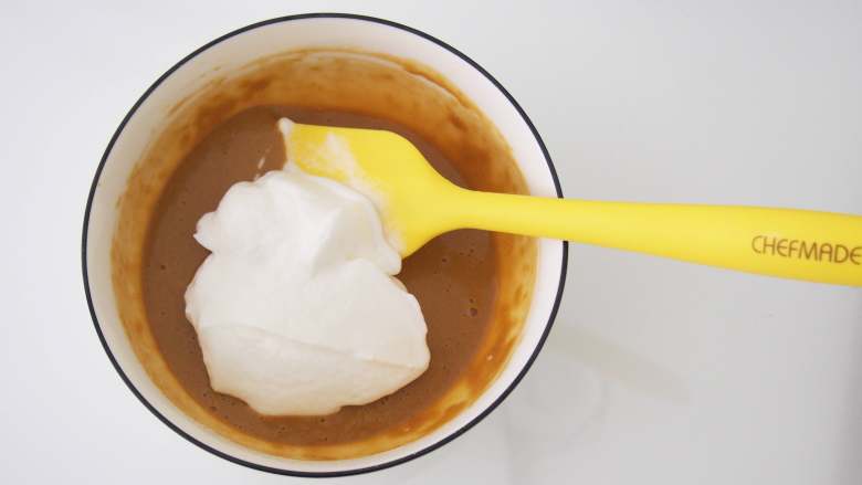 咖啡奶油卷,将三分之一的蛋白霜加入蛋黄糊中，切拌均匀。
