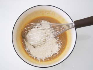 咖啡奶油卷,筛入低筋面粉，用蛋抽快速划Z字搅拌至无颗粒，放置一旁备用。