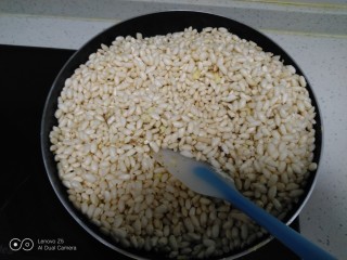 儿时小零食~江米球,倒入大米花，倒入玉米糖浆搅拌均匀。