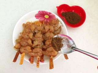 烤香辣串串虾,在每串虾仁上均匀的撒上一层孜然粉