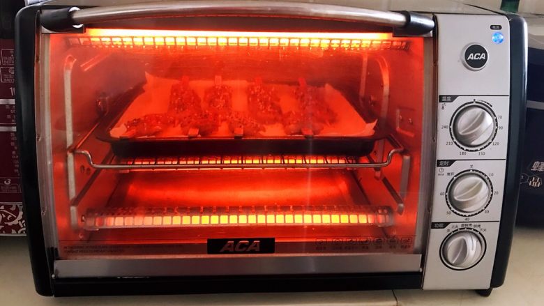 烤香辣串串虾,把烤盘放入预热好的烤箱里，上下火200W烤10分钟