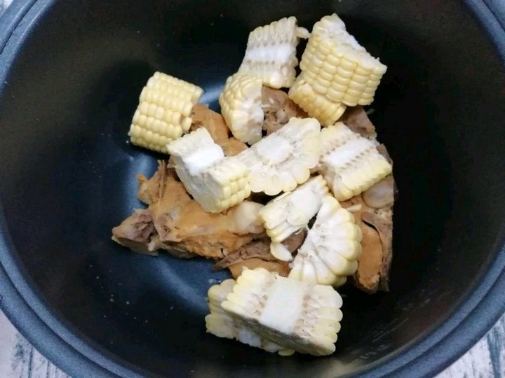 大骨玉米莲藕汤,把焯好的大骨放入电饭煲锅中，再放入玉米