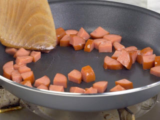 老上海沙拉,炒锅放入猪油烧热，放入红肠丁，加入少许盐，炒香盛出


