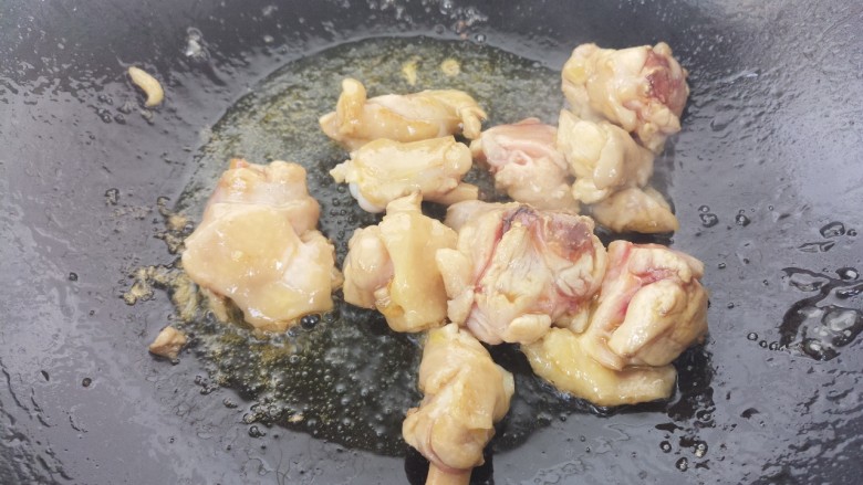 香菇青椒焖鸡,冰糖溶化呈棕红色。加入鸡腿炒。