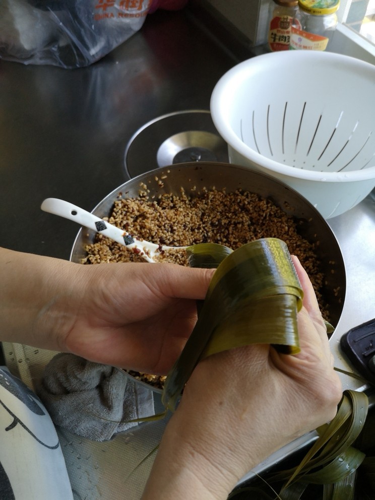 肉粽子,然后把粽叶覆盖上去
顺着粽子的形状包着转